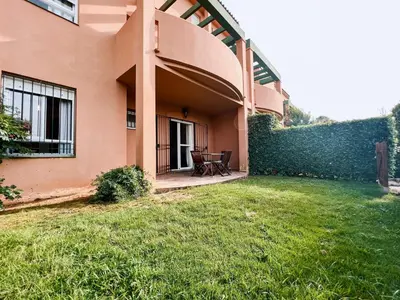 a house with a patio and a grass yard at Jardín del Golf Nº 36 by Fontanilla del Mar Holidays Rentals in Chiclana de la Frontera