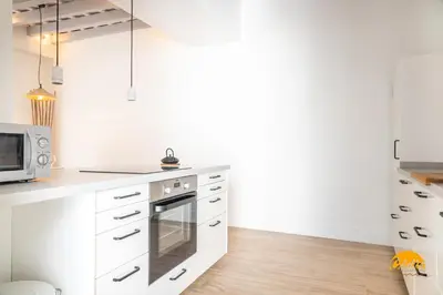 a kitchen with white cabinets and a microwave at Tiles Home by Cadiz Time in Cádiz