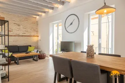 a dining room with a table and a clock on the wall at Tiles Home by Cadiz Time in Cádiz