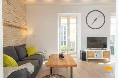 a living room with a couch and a clock on the wall at Tiles Home by Cadiz Time in Cádiz