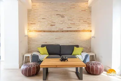 a living room with a couch and a wooden table at Tiles Home by Cadiz Time in Cádiz