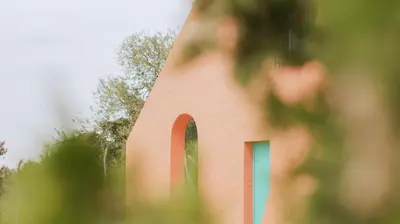 a red building with an arched window on it at Casa Rural Los Garrovillos by Fontanilla del Mar Holidays Rentals in Conil de la Frontera