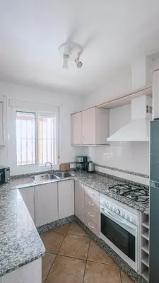 a kitchen with white cabinets and a stove top oven at Casa Rural Los Garrovillos by Fontanilla del Mar Holidays Rentals in Conil de la Frontera