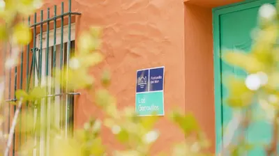 a sign on the side of a building with a green door at Casa Rural Los Garrovillos by Fontanilla del Mar Holidays Rentals in Conil de la Frontera