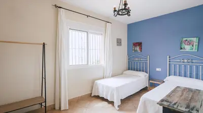 a bedroom with two beds and a window at Casa Rural Los Garrovillos by Fontanilla del Mar Holidays Rentals in Conil de la Frontera