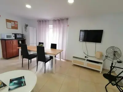 a living room with a table and chairs and a television at La Casona de Rances Grupo AC Gestion in Cádiz