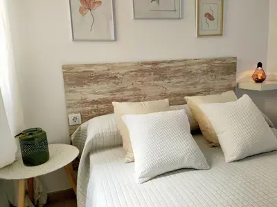 a bed with white pillows and a wooden headboard at RELAX CHICLANA-Aparcamiento privado-TV Cable-WifiPlus-Aire Acond-Incluido in Chiclana de la Frontera