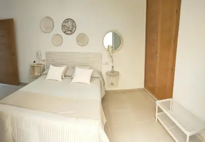 a bedroom with a white bed with two pillows at RELAX CHICLANA-Aparcamiento privado-TV Cable-WifiPlus-Aire Acond-Incluido in Chiclana de la Frontera
