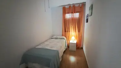a small room with two beds and a window at Apartamento Playa La Barrosa in Chiclana de la Frontera
