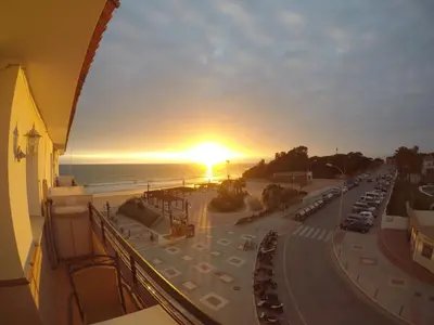 a sunset over a street with cars parked on the street at Apartamento Playa La Barrosa in Chiclana de la Frontera