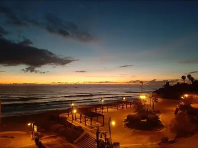 a view of the ocean at night with lights at Apartamento Playa La Barrosa in Chiclana de la Frontera
