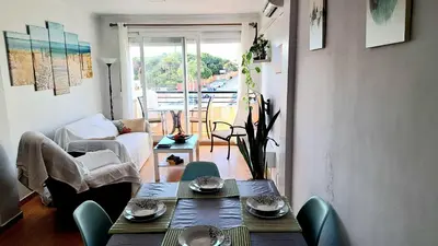 a living room with a table and chairs and a couch at Apartamento Playa La Barrosa in Chiclana de la Frontera