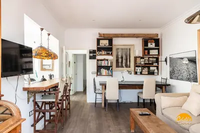 a living room and dining room with a table and chairs at La Bella Escondida by Cadiz Time in Cádiz