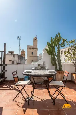 a table and chairs on a balcony with a cactus at La Bella Escondida by Cadiz Time in Cádiz