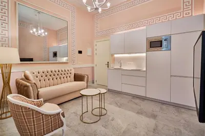 a living room with a couch and a kitchen at Tandem Palacio Veedor de Galeras Suites in Cádiz