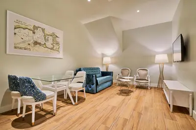 a living room with a glass table and chairs at Tandem Palacio Veedor de Galeras Suites in Cádiz