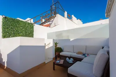 a living room with white walls and a couch at Atico & Jacuzzi CRUZ by Cadiz4Rentals in Cádiz