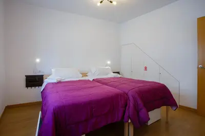 a bed with a purple blanket on top of it at Atico & Jacuzzi CRUZ by Cadiz4Rentals in Cádiz