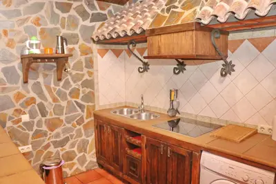 a kitchen with a sink and a stone wall at Chalet Bella Mendoza in Conil de la Frontera