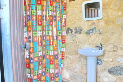a bathroom with a shower curtain with a sink at Chalet Bella Mendoza in Conil de la Frontera