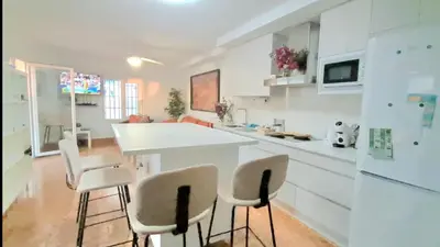 a kitchen with white counters and white appliances at Casa mirando al mar, hermosas vistas. in Chipiona