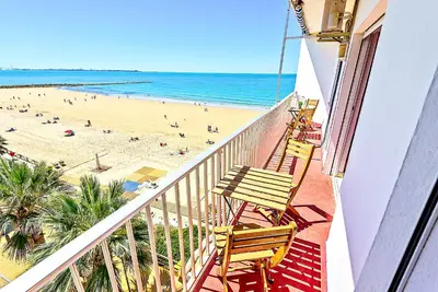 a balcony with chairs and a beach and the ocean at En Playa Apartamento con Balcón, Wifi in El Puerto de Santa María