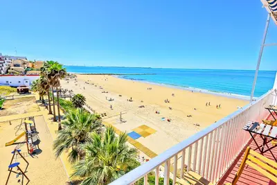 a view of a beach with palm trees and the ocean at En Playa Apartamento con Balcón, Wifi in El Puerto de Santa María