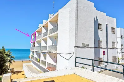 a white building on the beach next to the ocean at En Playa Apartamento con Balcón, Wifi in El Puerto de Santa María