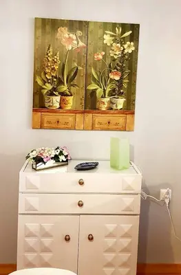 a painting of potted plants on top of a dresser at APARTAMENTO CORTADURA BEACH in Cádiz
