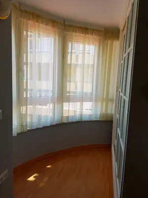 an empty room with two windows and a wooden floor at APARTAMENTO CORTADURA BEACH in Cádiz