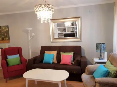 a living room with a brown couch with colorful pillows at APARTAMENTO CORTADURA BEACH in Cádiz