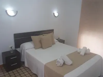 a bedroom with a bed with two towels on it at Hospederia Islasol in San Fernando