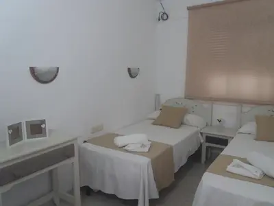 a hotel room with two beds and a sink at Hospederia Islasol in San Fernando