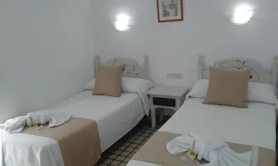 a room with two beds and a table with towels at Hospederia Islasol in San Fernando