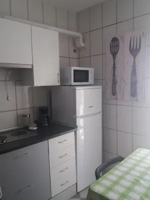 a small kitchen with a microwave and a refrigerator at Hospederia Islasol in San Fernando