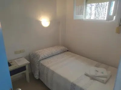 a small bedroom with a bed and a window at Hospederia Islasol in San Fernando