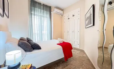 a bedroom with a bed with a red blanket on it at Cadiz Cinema Grupo AC Gestion in Cádiz