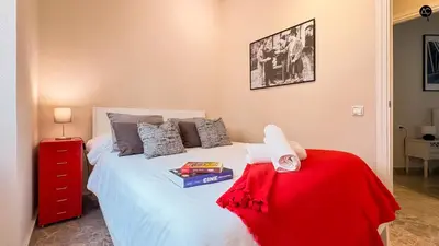 a bedroom with a white bed with a red dresser at Cadiz Cinema Grupo AC Gestion in Cádiz