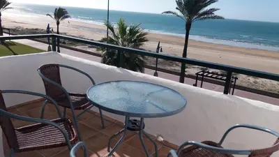 a table and chairs on a balcony overlooking the beach at Primera linea de playa 