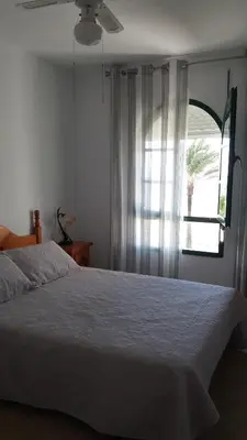 a bedroom with a white bed and a window at Primera linea de playa 