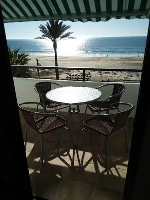a table and chairs with a view of the beach at Primera linea de playa 