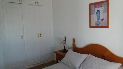 a bedroom with a bed and a picture on the wall at Primera linea de playa 