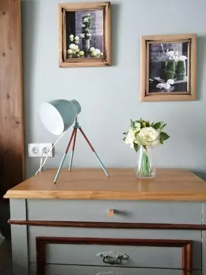 a lamp and a vase of flowers on a dresser at Casa de Lys in Sanlúcar de Barrameda