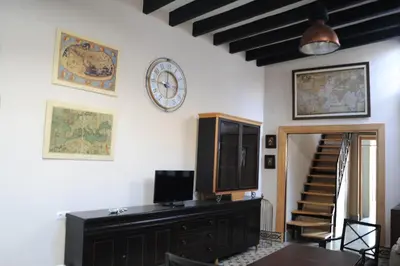 a room with a clock on the wall and a table at Casa de Lys in Sanlúcar de Barrameda