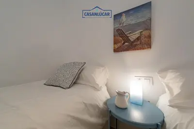 a bedroom with a bed and a table with a lamp at Parque Doñana in Sanlúcar de Barrameda
