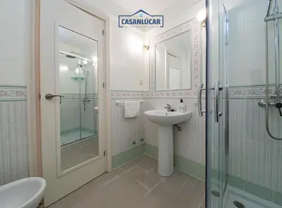 a white bathroom with a sink and a shower at Parque Doñana in Sanlúcar de Barrameda