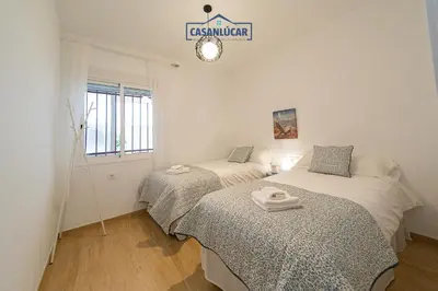 two beds in a room with a sign on the wall at Parque Doñana in Sanlúcar de Barrameda