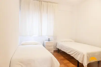 two beds in a white room with a window at Villa Lola by Cadiz Time in Cádiz