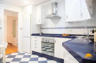 a kitchen with white cabinets and a checkered floor at Villa Lola by Cadiz Time in Cádiz