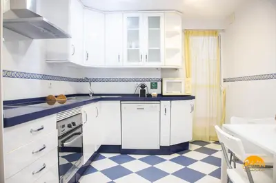 a kitchen with white cabinets and a checkered floor at Villa Lola by Cadiz Time in Cádiz